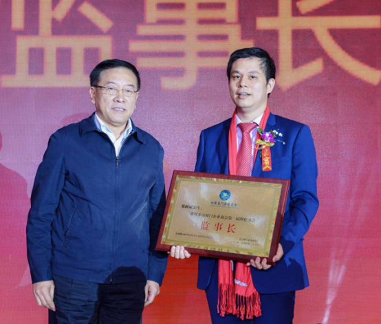全國歸國華僑聯合會主席林軍先生（左一）為仟億達集團董事長鄭兩斌（右一）頒發(fā)監(jiān)事長牌匾